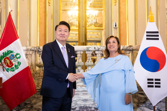Korean President Yoon Suk Yeol, left, shakes hands with Peruvian President Dina Boluarte after their joint press briefing at the Palacio de Gobierno in Lima, Peru, following their bilateral summit on Saturday. [JOINT PRESS CORPS]