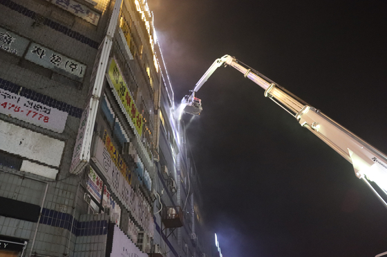 Firefighters hose down the commercial building in Gyeonggi on Sunday. [GYEONGGI FIRE & DISASTER HEADQUARTERS]