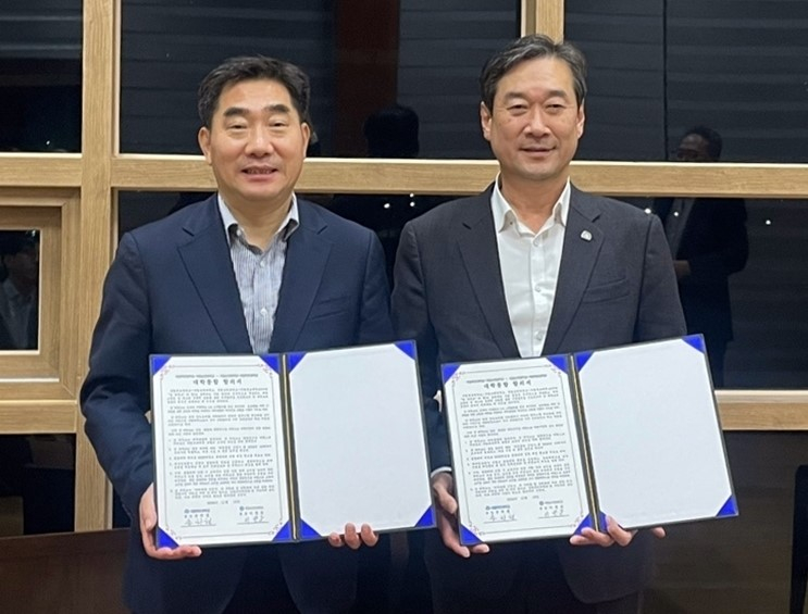 Sunchon National University President Lee Byung-woon, left, and Mokpo National University President Song Ha-cheol pose for a photo after signing an agreement to merge by March 2026. [MOKPO NATIONAL UNIVERSITY]