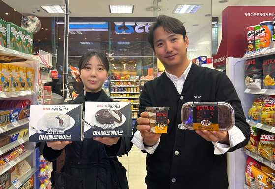 Models hold up GS25's marshmallow cake and tiramisu products inspired by Netflix show "Culinary Class Wars." [GS RETAIL]