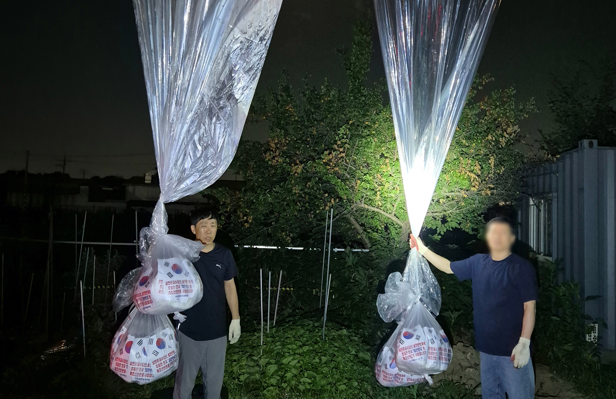 Members of the North Korean defectors group Fighters for a Free North Korea hold large balloons carrying anti-Pyongyang leaflets in northern Gyeonggi in June. [NEWS1]