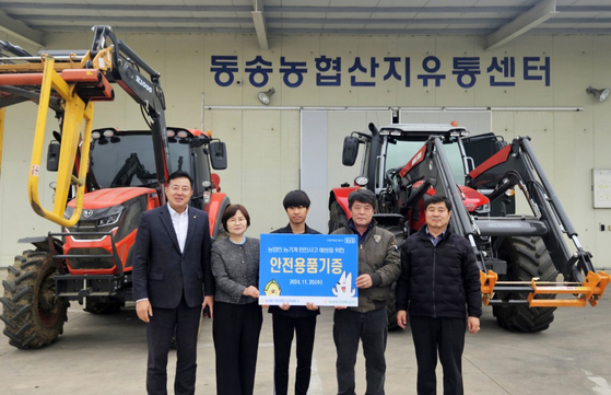 Officials from the Gangwon branch of the National Agricultural Cooperative Federation, commonly known as Nonghyup, take a commemorative photo at the Dongsong Agricultural Cooperative Association Rice Processing Center in Cherwon County, Gangwon, on Wednesday. [YONHAP]
