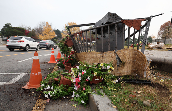 The fence and potted flowers in the water fountain square in front of the Blue House in Jongno District, central Seoul, were damaged after a teenager drove a car into them on Thursday. [YONHAP]