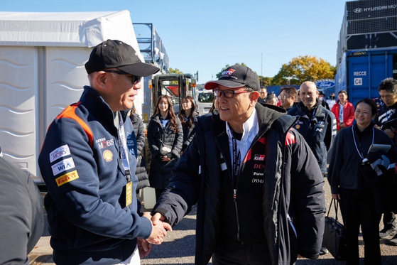 Hyundai Motor Executive Chair Euisun Chung, left, shakes hands with Toyota Motor Chairman Akio Toyoda at Toyota Gazoo Racing Park on Sunday ahead of the 2024 World Rally Championship held at Toyota Stadium. [HYUNDAI MOTOR]
