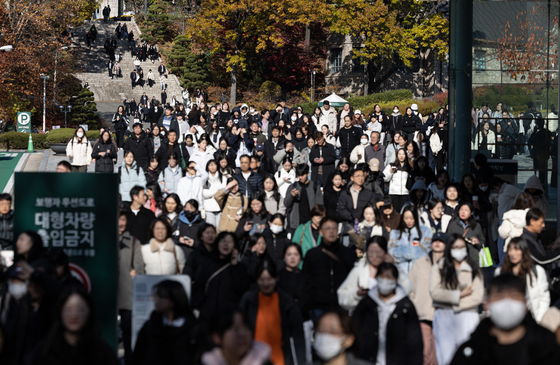 Students stream out of an exam site after completing the essay test for the 2025 academic year early admission, held on Sunday afternoon at Ewha Womans University in Seodaemun District, western Seoul. [NEWS1]