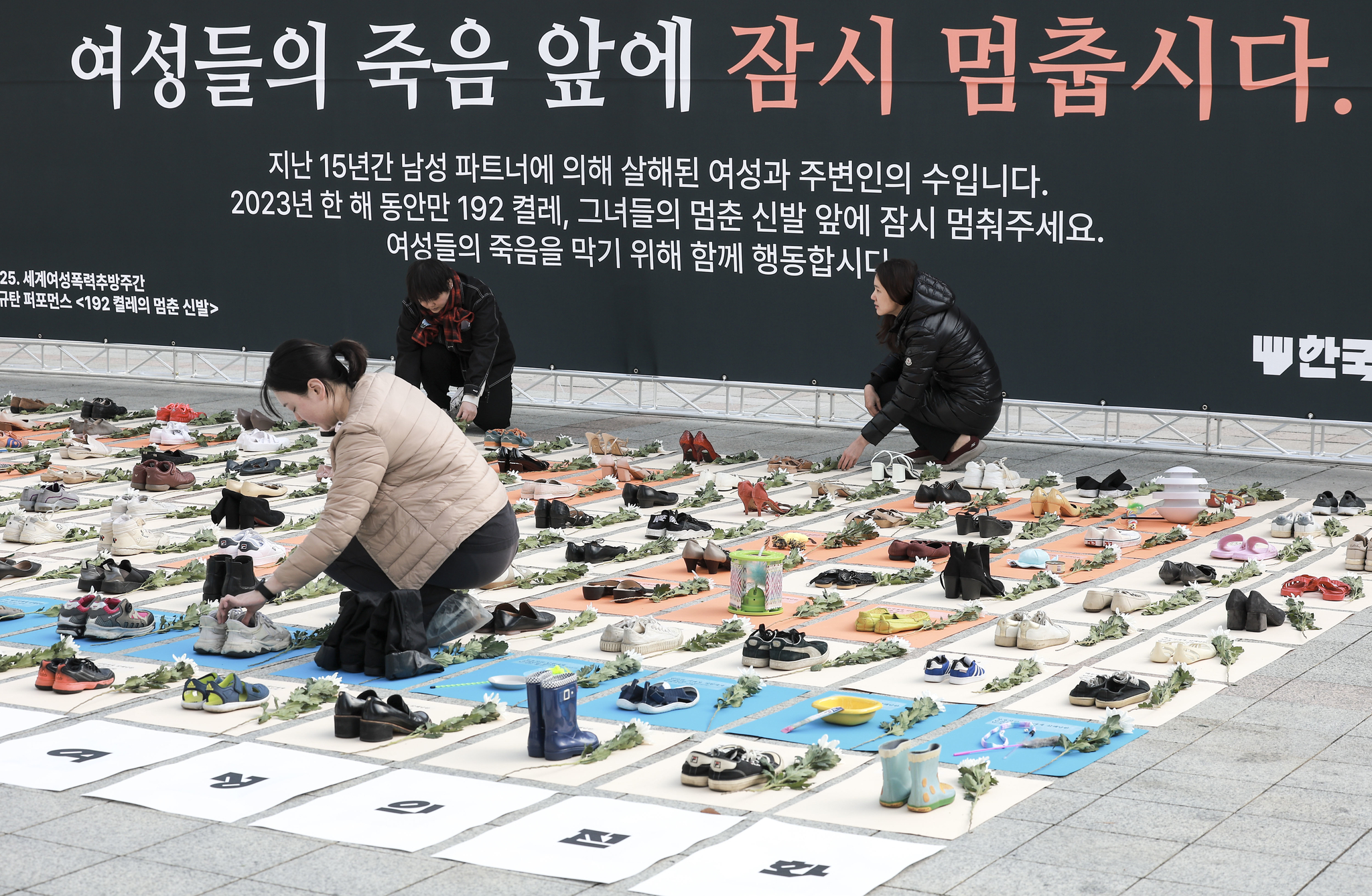 An activist arranges pairs of shoes in front of Bosingak Pavilion in Jongno District, central Seoul, on Monday, which were part of a protest performance conducted by women’s rights activist group Korea Women’s Hot-Line. [NEWS1]