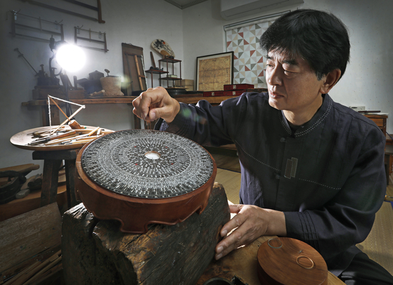 Kim Hee-su, a craftsman who practices the traditional technique of making yundo (a traditional compass), works on his creation at the Yundojang Training Center in Naksan Village, Gochang County, North Jeolla. [PARK SANG-MOON] 