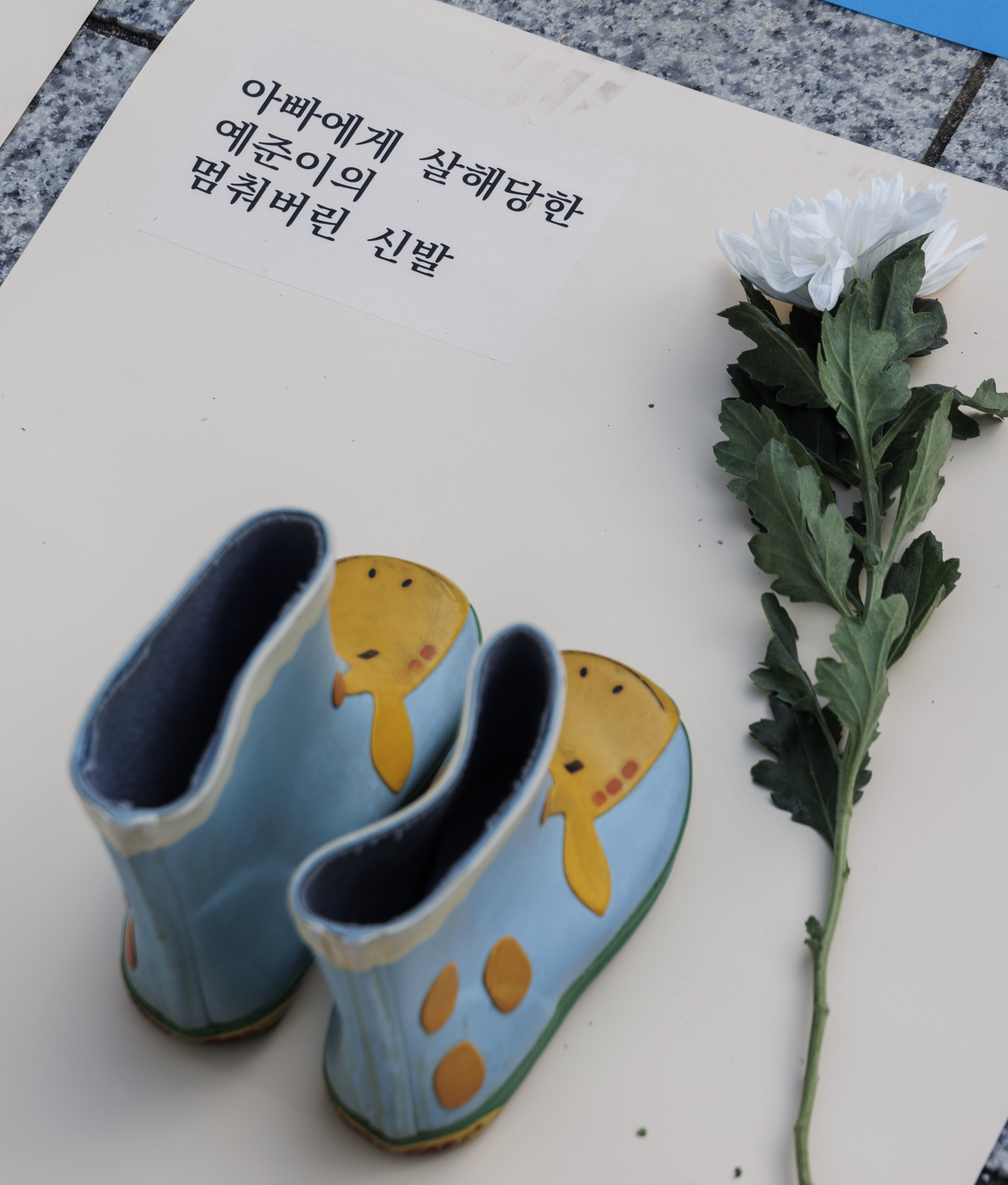 A pair of shoes is placed in front of Bosingak Pavilion in Jongno District, central Seoul, on Monday as part of the protest performance conducted by women’s rights activist group Korea Women’s Hot-Line. The sheet of paper includes the victim's name as well as how she died: "The shoes of Ye-joon, who was killed by her father." [NEWS1]