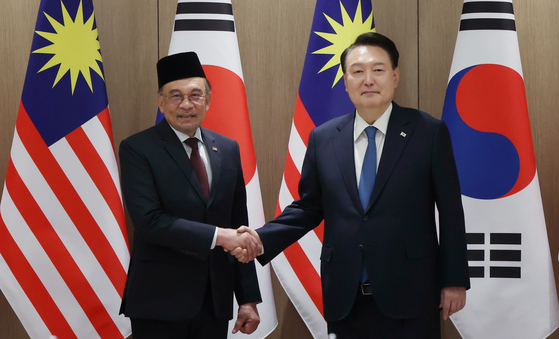President Yoon Suk Yeol, right, and Malaysian Prime Minister Anwar Ibrahim pose for a photo ahead of their summit held at the presidential office in Yongsan, central Seoul on Monday. [YONHAP]