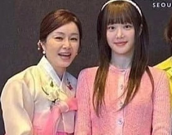 Actor Lee Yu-bi donning a bright pink jacket poses for a photo at her sister's wedding ceremony. [SCREEN CAPTURE]
