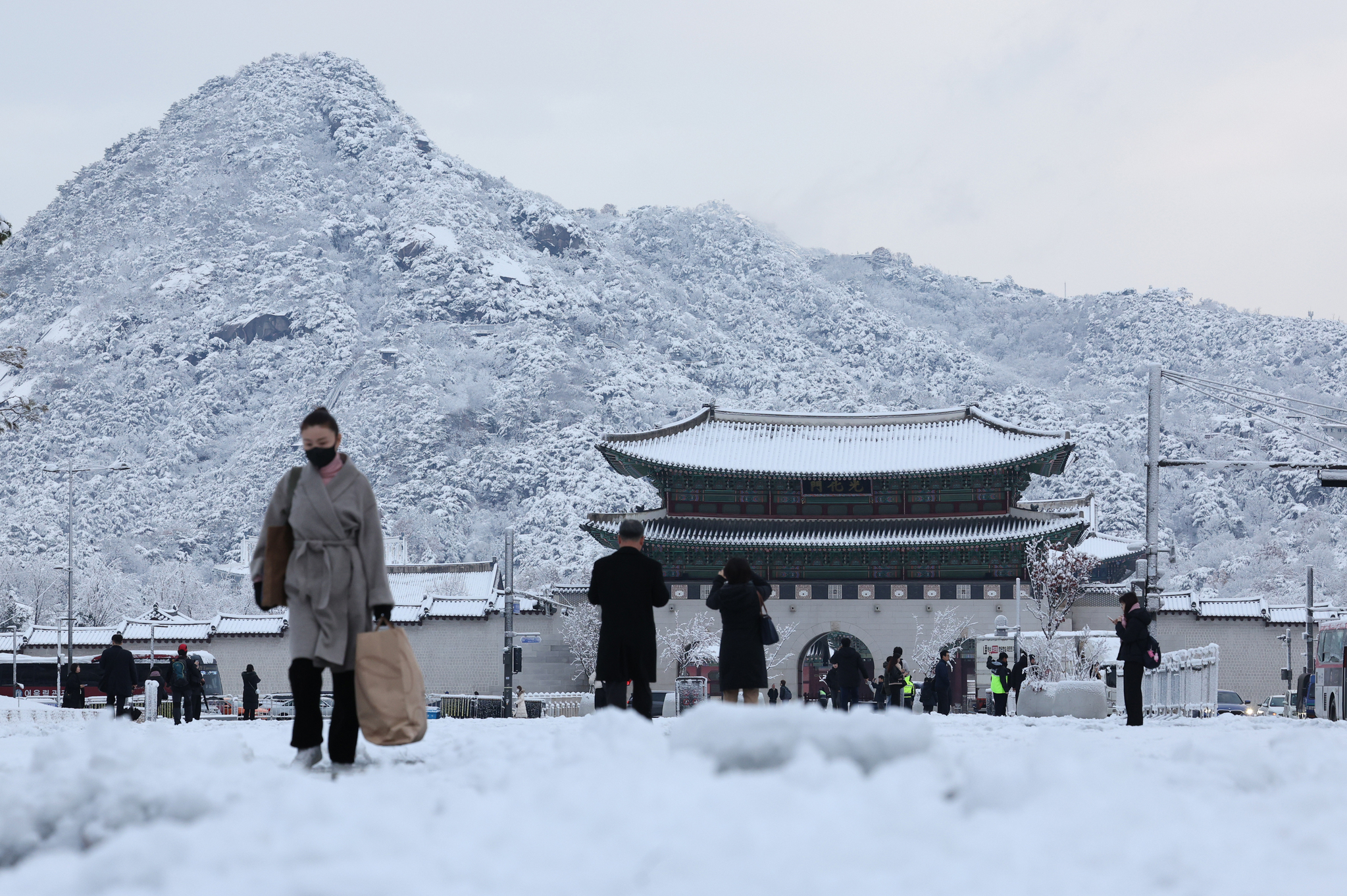 Pedestrians walk on a path blanketed by snow on Wednesday morning in Jongno District, central Seoul. [NEWS1]