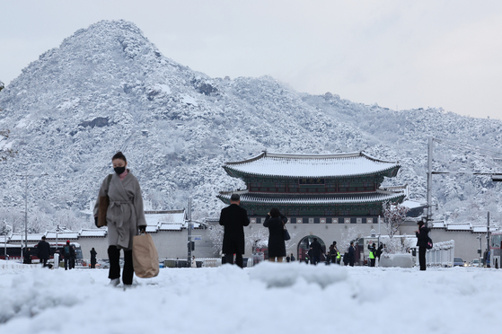 People walk the snow-covered streets of Jongno District, central Seoul on Wednesday. [NEWS1]
