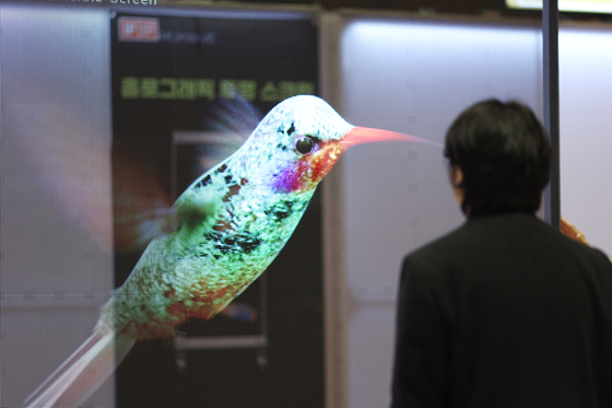 An attendee views a holographic screen during Korea Meta Expo (KME) 2024 at Coex in Gangnam District, southern Seoul, on Wednesday. [YONHAP]