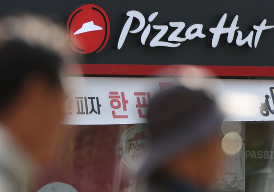 Passerbys walk by a Pizza Hut store in Seoul on Nov. 5. [YONHAP]