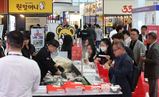Visitors look around booths at the International Franchise Show at the Coex convention center in Gangnam District, southern Seoul, on Oct. 31. [YONHAP]