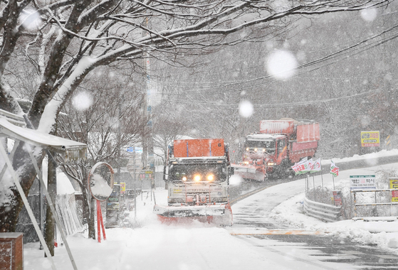 A snowplower drives through a street covered in snow in Geochang County, South Gyeongsang on Wednesday. [YONHAP]