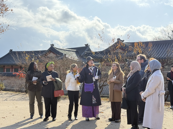 Spouses of foreign ambassadors to Korea listen to a tour guide's explanation at Gyeongbok Palace in central Seoul on Tuesday. [LEE SOO-JUNG]