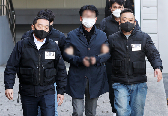 The 67-year-old who attacked Democratic Party chief Lee Jae-myung is being escorted from a police station in Busan to attend an arrest warrant hearing at the Busan District Court on Jan. 4. [NEWS1] 
