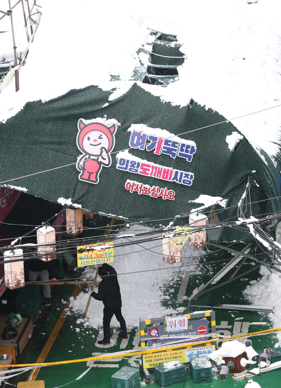 Workers carry out restoration work at a traditional market in Uiwang, Gyeonggi, after its ceiling collapsed around 1:30 a.m. Thursday due to record heavy snowfall in the greater Seoul area. [NEWS1] 