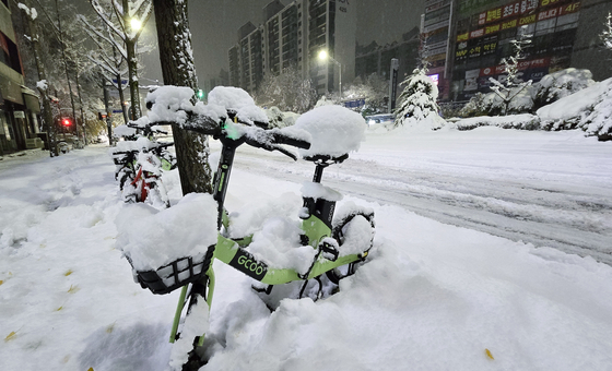 A bicycle is seen covered in snow in Seongnam, Gyeonggi, on Thursday morning. [YONHAP] 