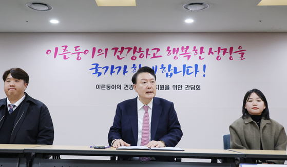 President Yoon Suk Yeol, center, speaks during a meeting with parents of premature babies at Seoul St. Mary's Hospital in southern Seoul on Thursday. [YONHAP] 