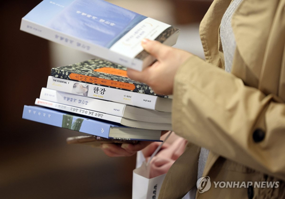 A woman buying Han Kang’s books at Kyobo Book Store in Gwanghwamun, Seoul. [YONHAP]