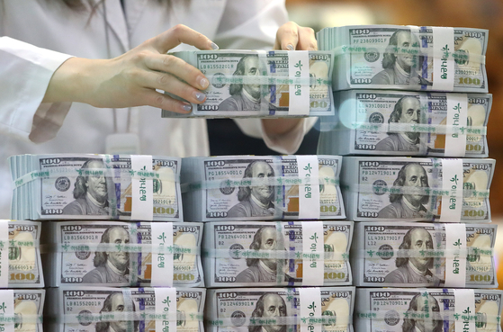 An employee arranges stacks of dollar bills at Hana Bank's Counterfeit Notes Response Center in Jung District, central Seoul, July 3.[NEWS1]