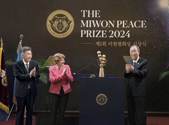 Former UN Secretary-General Ban Ki-moon, right, claps as he receives the trophy for the inaugural Miwon Peace Prize on behalf of The Elders at Kyung Hee University's Peace Hall in Dongdaemun District, eastern Seoul, on Friday. Kyung Hee University Chancellor Choue In-won, far left, and former Director-General of Unesco Irina Bokova clap to congratulate Ban. [PARK SANG-MOON]