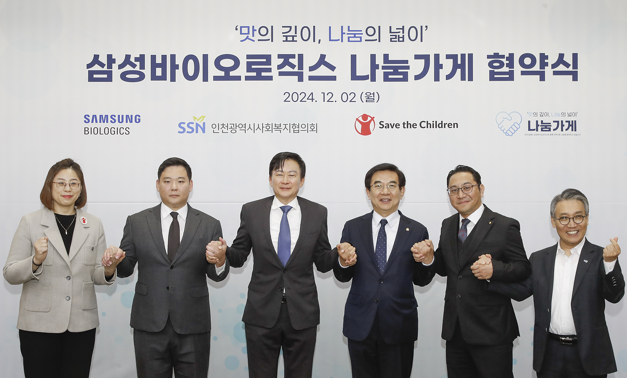 Samsung Biologics CEO John Rim, third from left, and union leader Park Jae-sung, second from left, pose for a photo at the commemorative ceremony of a corporate social responsibility program launch with other government officials and nongovernmental organization representatives at the company’s headquarters in Songdo, Incheon, on Monday. [SAMSUNG BIOLOGICS]