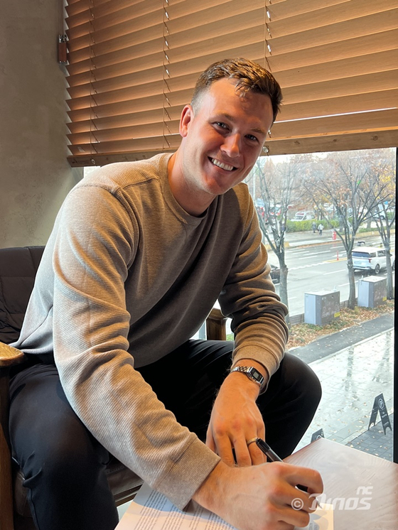 Riley Thompson signs his contract with the NC Dions on Sunday. [YONHAP] 