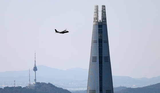 A military helicopter flies near Lotte World Tower in Songpa District, southern Seoul on Sept. 24, as part of a rehearsal for Armed Forces Day. [NEWS1] 