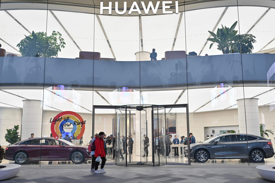 People are seen inside a Huawei store at the Wangfujing shopping area in Beijing on November 26, 2024, shortly after Huawei's new Mate 70 mobile phone was launched. [AFP/YONHAP]