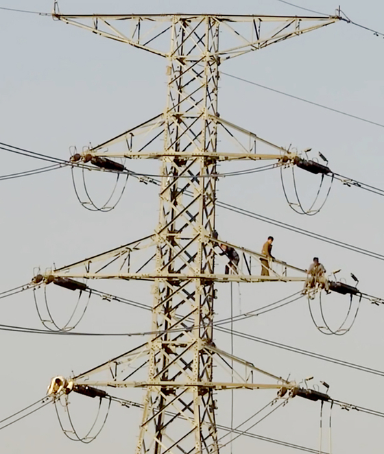North Korean workers are seen removing wires from a transmission tower near the border north of the Gyeongui Line military demarcation line (MDL) in this video released by the South's Unification Ministry on Tuesday. [MINISTRY OF UNIFICATION]
