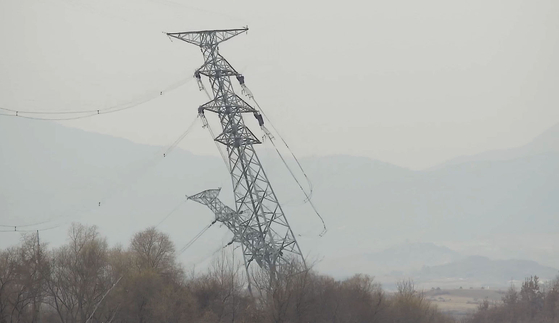 A transmission tower near the border north of the Gyeongui Line military demarcation line (MDL) falls on after wires are removed in this video released by the South's Unification Ministry on Tuesday. [MINISTRY OF UNIFICATION]