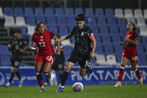 Korea's Lim Seon-joo, center, duels for the ball with Canada's Olivia Smith during an international friendly at the Pinatar Arena Football Center in Spain on Tuesday.  [AP/YONHAP]