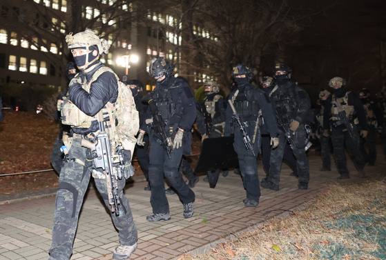 Armed martial forces retreat from the National Assembly in western Seoul in the early hours Wednesday after parliamentarians voted against martial law declared by Yoon Suk Yeol. [YONHAP]  