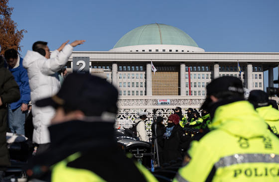 Citizens and members of civic groups on Wednesady gather in front of the main gate of the National Assembly in Yeouido, western Seoul, condemning President Yoon Suk Yeol after the declaration of emergency martial law on Tuesday. [NEWS1]