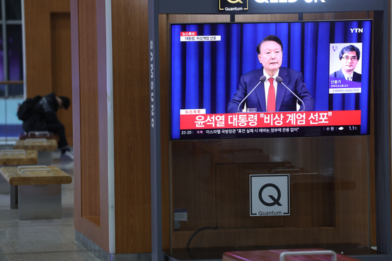 A TV screen at Seoul Station in central Seoul shows a broadcast where Yoon Suk Yeol declared emergency martial law on Tuesday evening. [YONHAP] 
