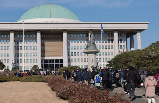 Citizens head to the main building of the National Assembly in Yeouido, western Seoul on Wednesday to attend an emergency meeting to call for President Yoon Suk Yeol's resignation and to push for his impeachment after he declared emergency martial law Tuesday night. [YONHAP]
