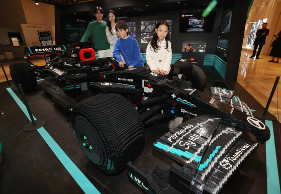 Models pose with a life-size Lego version of the Mercedes AMG F1 race car at Lotte World Mall in Songpa District, southern Seoul, on Thursday. [YONHAP]