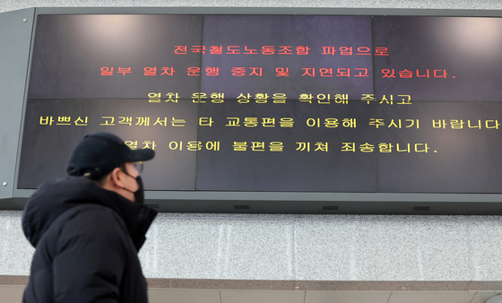 A passerby reads a digital board at Gwangju Songjeong Station showing train cancellations due to the Korean Railway Workers’ Union’s general strike, which began on Thursday. [YONHAP]