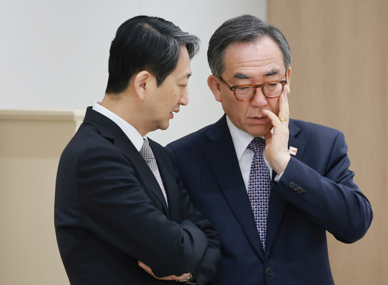 Foreign Minister Cho Tae-yul, right, speaks to Industry Minister Ahn Duk-guen at the Yongsan presidential office on Tuesday. [YONHAP] 