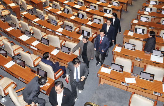 The president's People Power Party (PPP) lawmakers walk out of the National Assembly chamber on Saturday afternoon as the impeachment motion against President Yoon Suk Yeol is introduced, leaving only Rep. Ahn Cheol-soo behind. [KIM SEONG-RYONG]