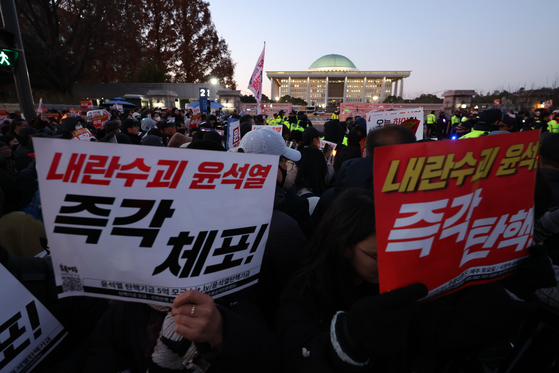 Protesters rally and call for the resignation of President Yoon Suk Yeol in front of the National Assembly in Yeouido, western Seoul on Friday. [NEWS1]