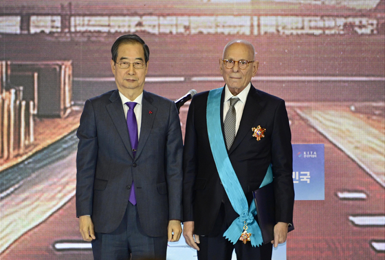 Prime Minister Han Duck-soo, left, poses with Ray Shipping Group Chairman Abraham Ungar who is the recipient of the Gold Tower Order of Industrial Service Merit at the 61st Trade Day Awards ceremony held in southern Seoul on Thursday. [INDUSTRY MINISTRY]