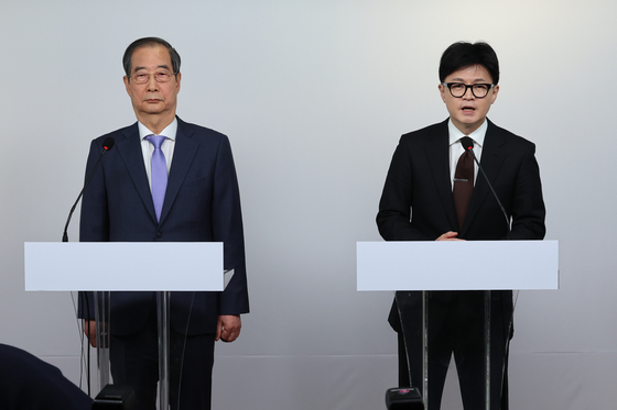 Prime Minister Han Duck-soo, left, and conservative People Power Party leader Han Dong-hoon participate in a joint public address in western Seoul on Sunday morning. [YONHAP] 