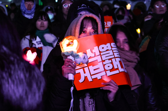 Protesters wave K-pop light sticks during a rally calling for President Yoon Suk Yeol's impeachment in Yeouido, Seoul, on Saturday. [JOONGANG ILBO]