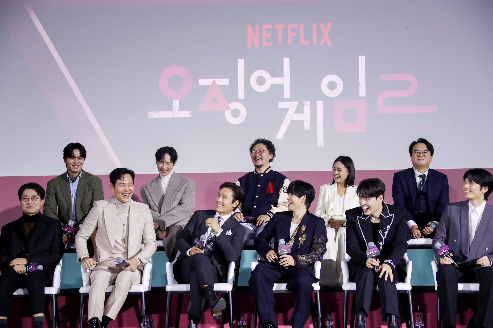 The cast and director of the second season of ″Squid Game″ (2021-) attend a press conference for the upcoming season held at the Dongdaemun Design Plaza in Jung District, central Seoul, on Dec. 9. From the front row, left, are director Hwang Dong-hyuk, actors Lee Jung-jae, Lee Byung-hun, Yim Si-wan, Kang Ha-neul and Wi Ha-jun. From the back row, left, are actors Lee Jin-uk, Park Sung-hoon, Yang Dong-geun, Kang Ae-sim and Lee Seo-hwan. [NEWS1]