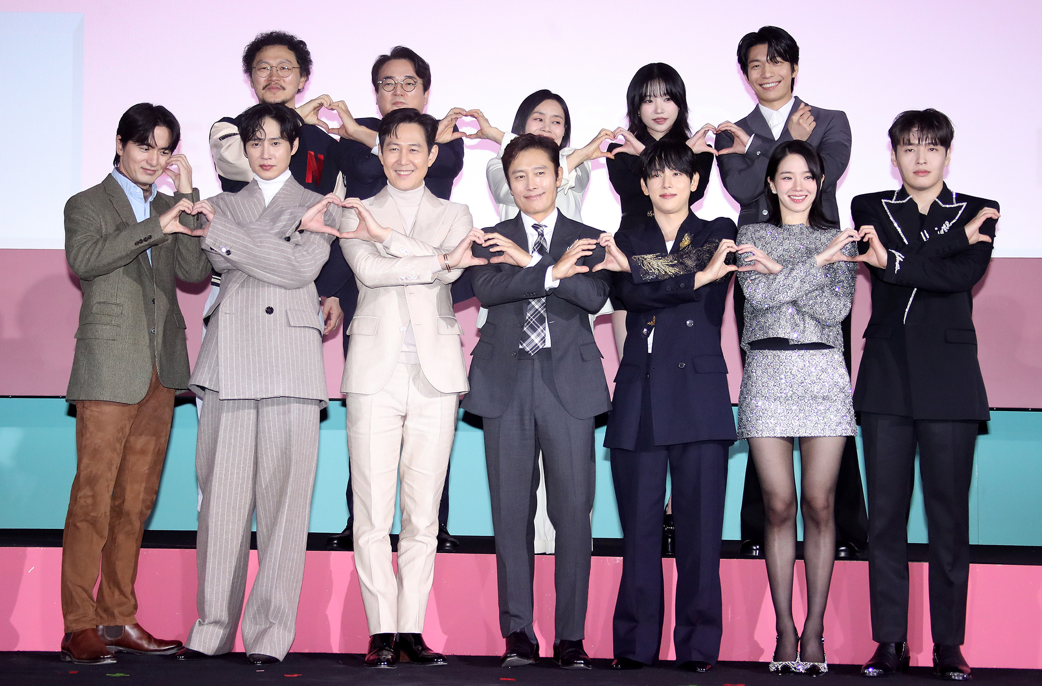 The cast and director of the second season of ″Squid Game″ (2021-) pose for photos during a press conference for the upcoming season held at the Dongdaemun Design Plaza in Jung District, central Seoul, on Dec. 9. From the front row, left, are actors Lee Jin-uk, Park Sung-hoon, Lee Jung-jae, director Hwang Dong-hyuk, actors Lee Byung-hun, Yim Si-wan, Park Gyu-young and Kang Ha-neul. From the back row, left, are actors Yang Dong-geun, Lee Seo-hwan, Kang Ae-sim, Jo Yu-ri and Wi Ha-jun.[NEWS1]