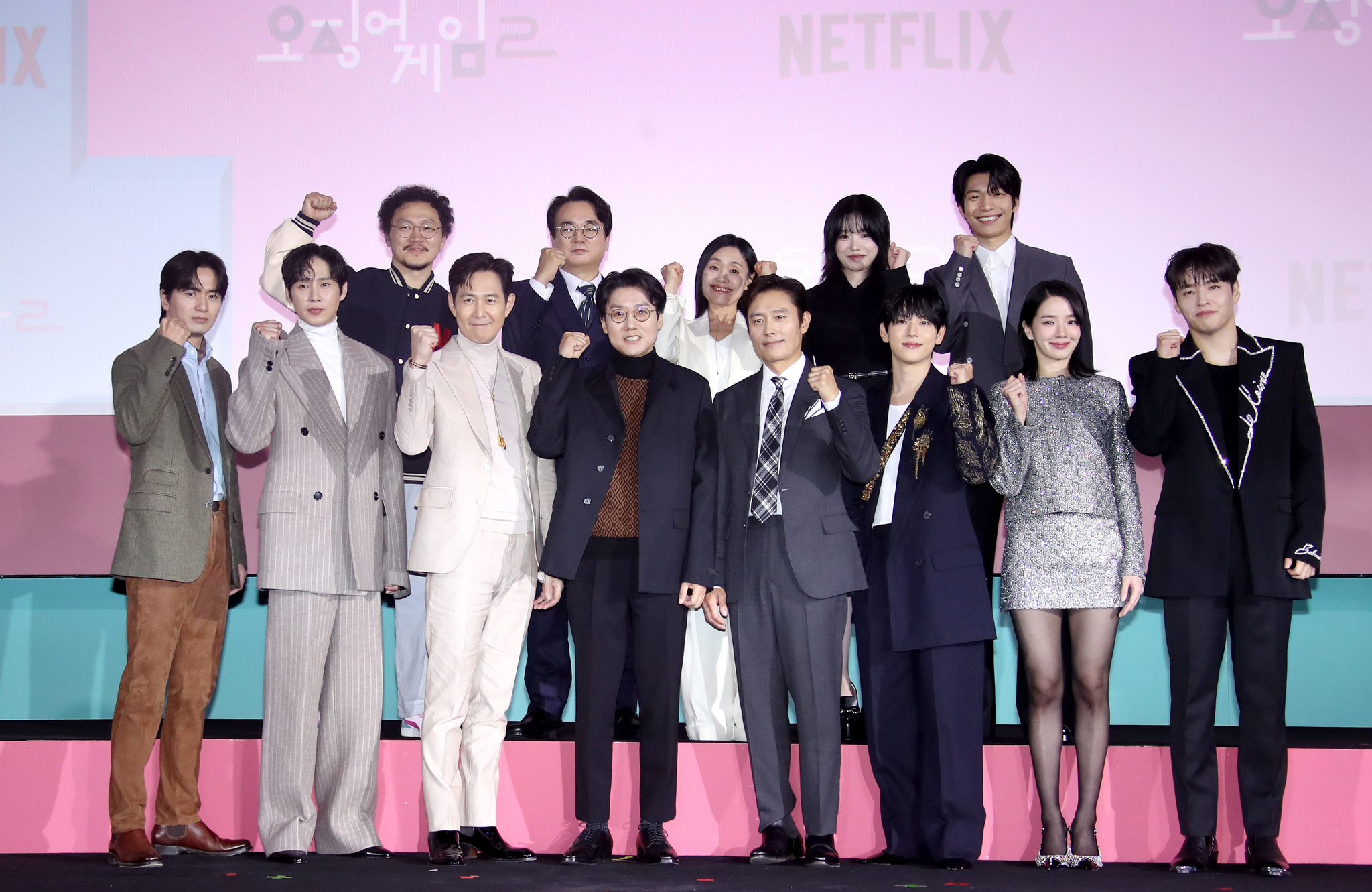 The cast and director of the second season of ″Squid Game″ (2021-) pose for photos during a press conference for the upcoming season held at the Dongdaemun Design Plaza in Jung District, central Seoul, on Dec. 9. From the front row, left, are actors Lee Jin-uk, Park Sung-hoon, Lee Jung-jae, director Hwang Dong-hyuk, actors Lee Byung-hun, Yim Si-wan, Park Gyu-young and Kang Ha-neul. From the back row, left, are actors Yang Dong-geun, Lee Seo-hwan, Kang Ae-sim, Jo Yu-ri and Wi Ha-jun [NEWS1]